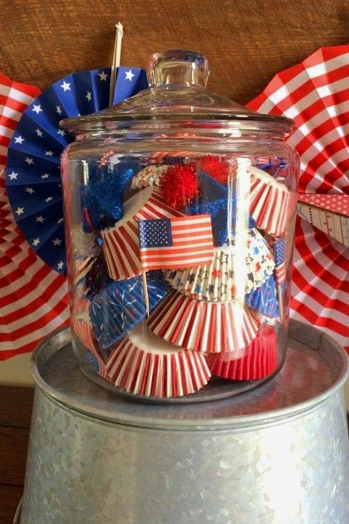 A clear jar with paper cupcake holders.