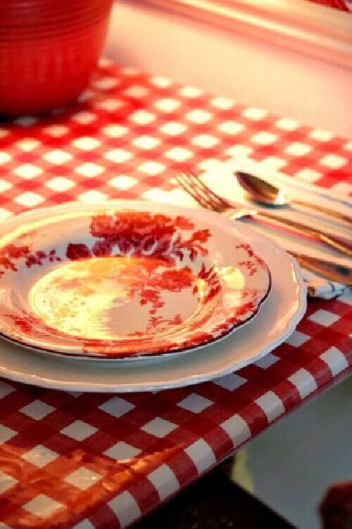 Red and white roses look extra special with this red and white checked oilcloth table.