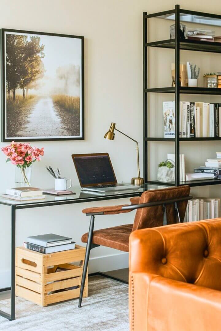 A glass desk and chair behind a living room couch.
