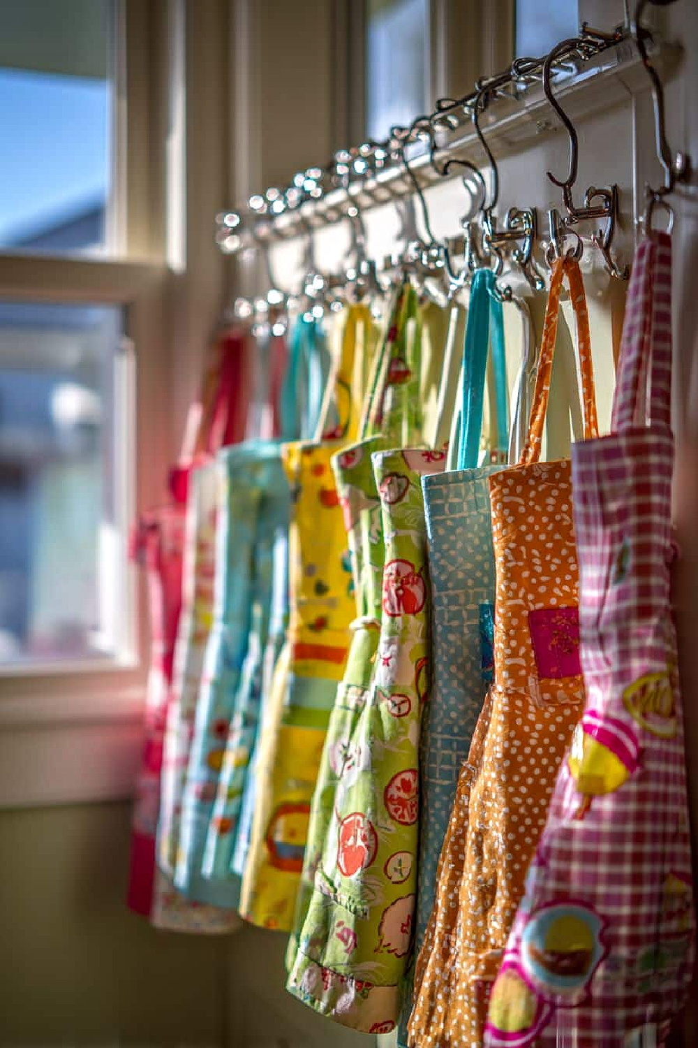 25 Ideas to Organize a Small Kitchen with No Cabinets is by using hooks to hold colorful aprons.