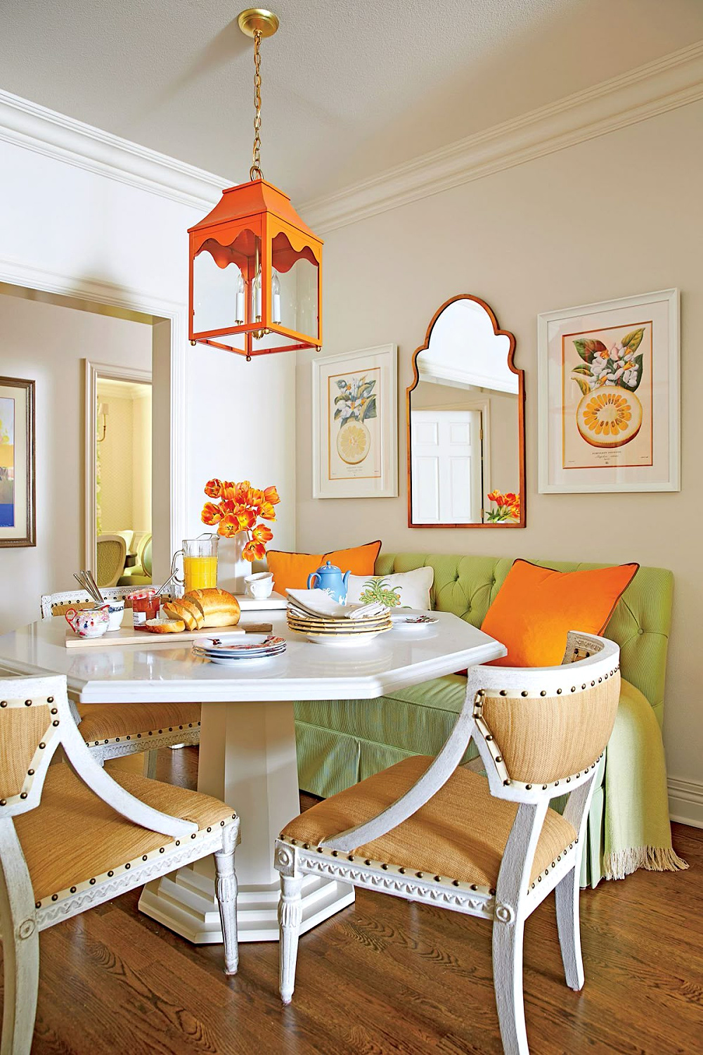 A pea-green loveseat, an octagonal white table, and two gold linen upholstered chairs.