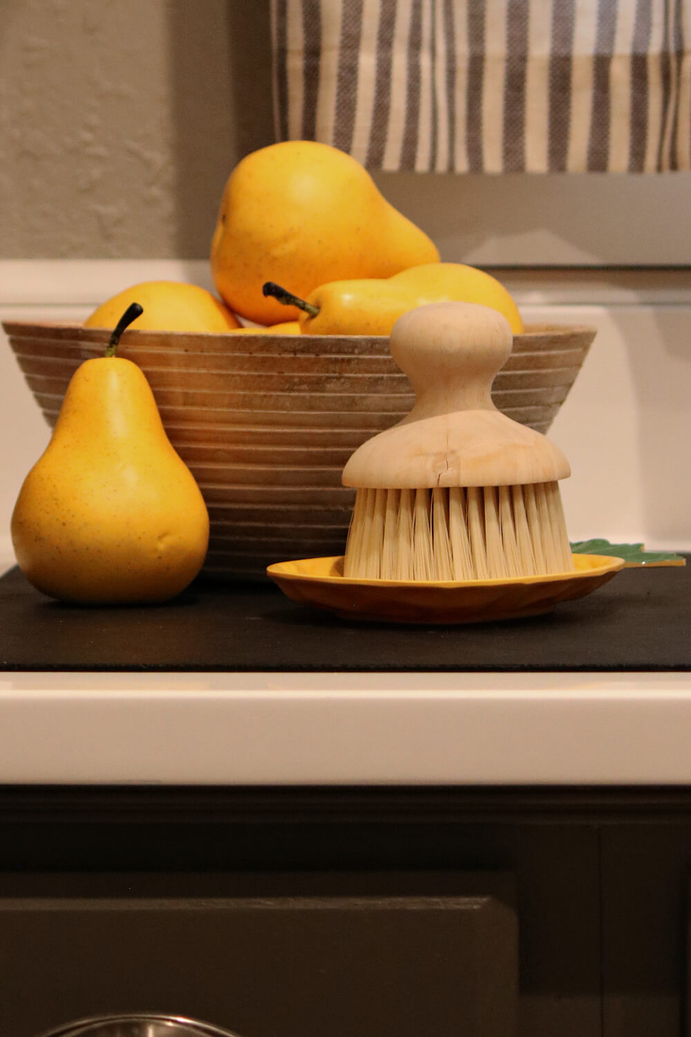 A wood bowl of faux yellow pears.