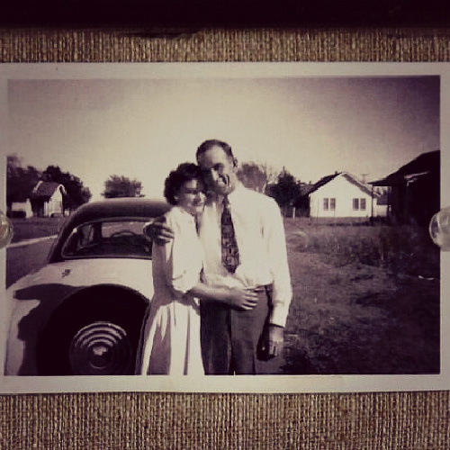 My mother and father in front of a car.