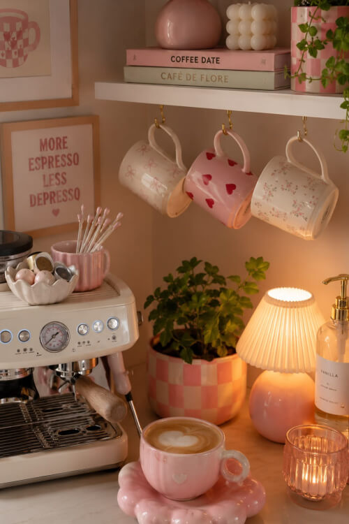 A corner set up of white shelves on the wall with hooks added underneath for cups.