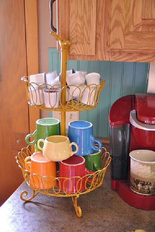 25 clever ways to display coffee mugs include this tiered stand with cups on the bottom tier.