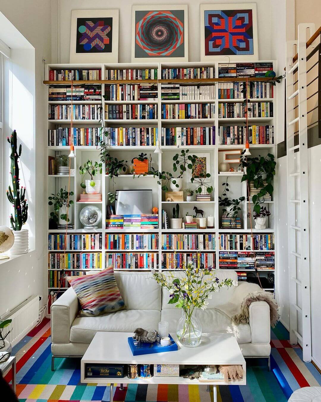 Vertical Living: Use Your Walls Wisely with a beige couch in front of a wall of bookshelves.