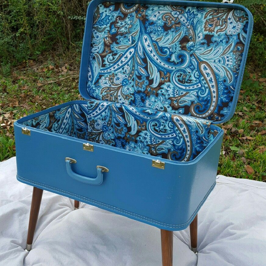 22 ideas to repurpose vintage suitcases includes this blue suitcase with blue, gray, black, and white paisley fabric.