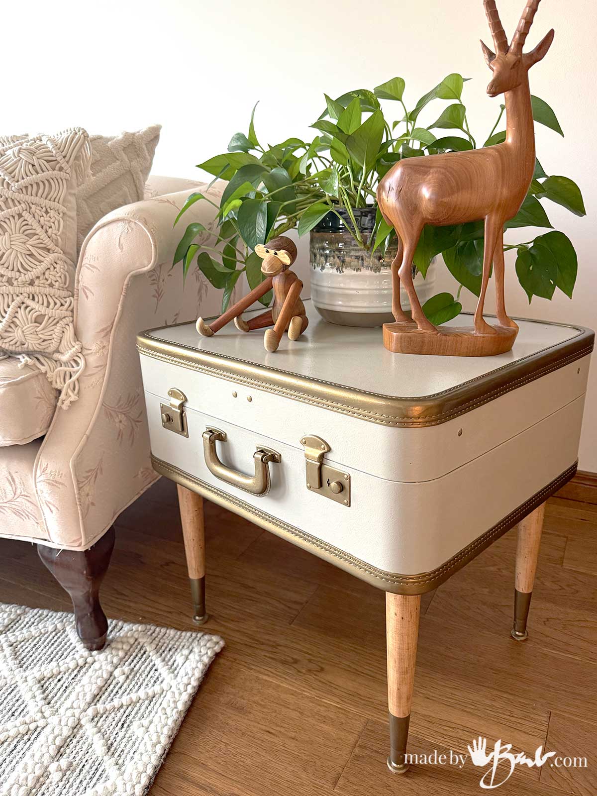22 ideas to repurpose vintage suitcases includes this side table with wooden animals and a plant.