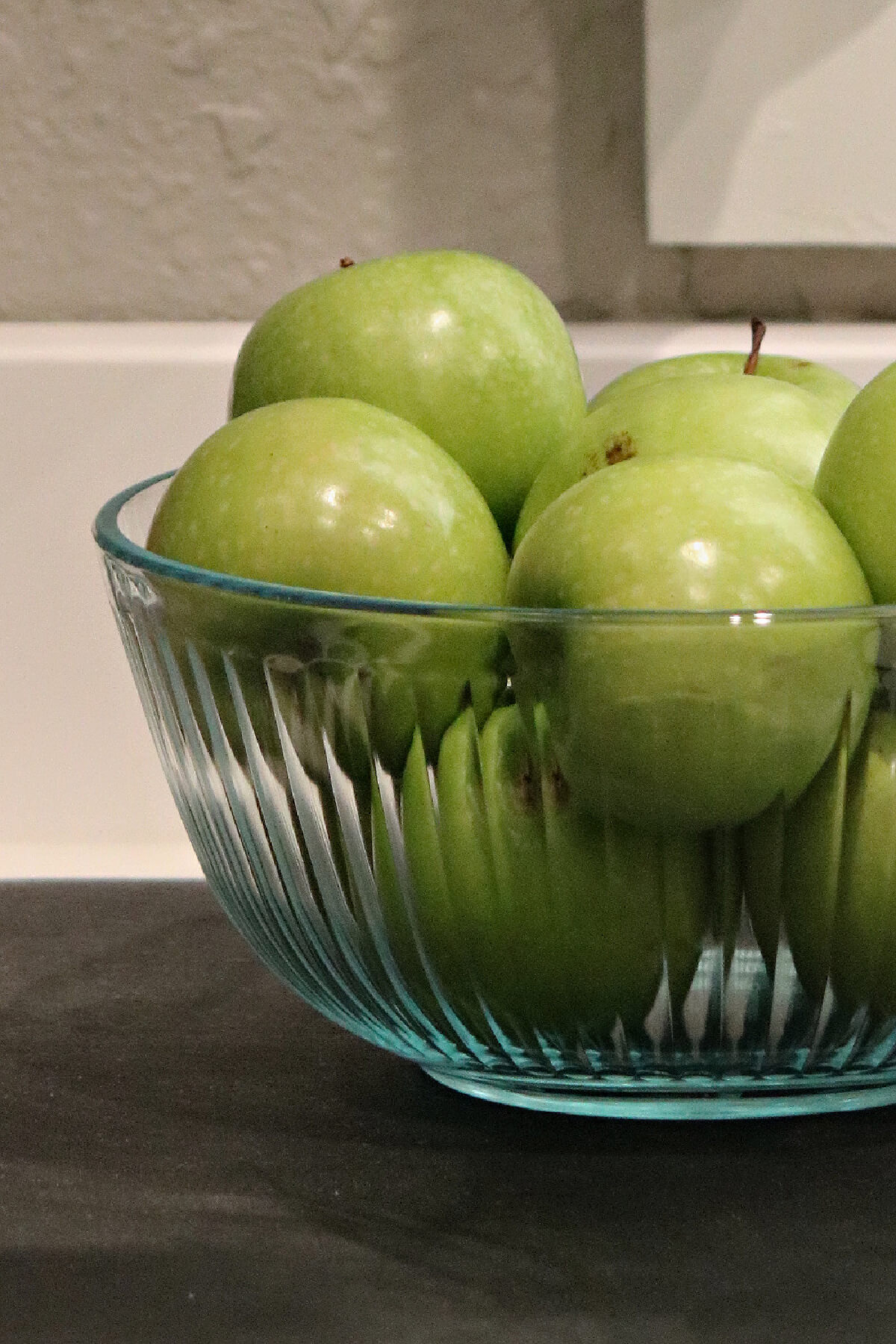 The rich colors of fall in my kitchen include these green apples in a clear glass bowl.
