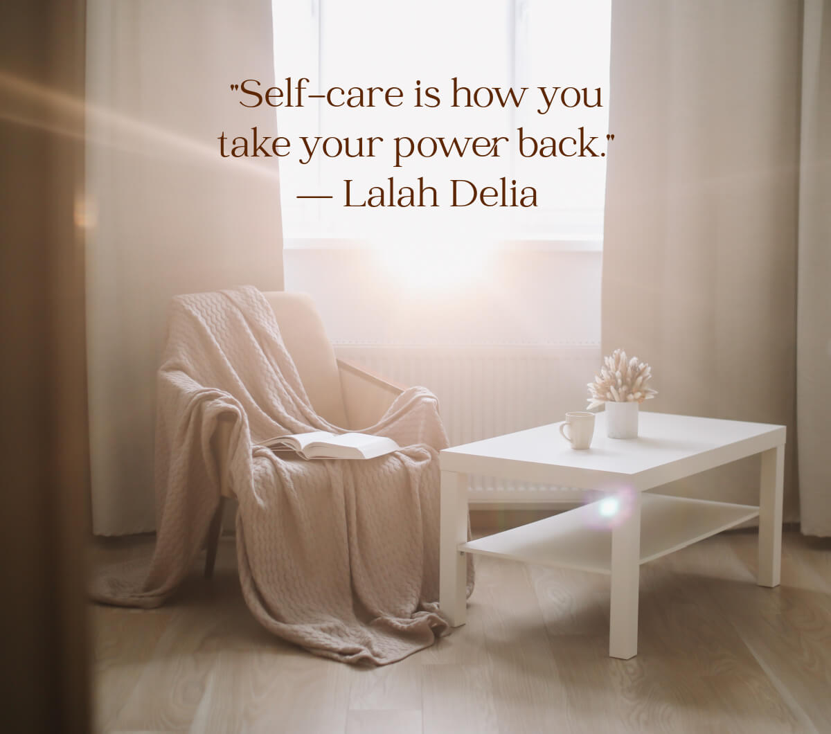 10 soothing self-care ideas for homebodies is how you take your power back. A chair covered with a blanket and a white coffee table with a mug and flowers.