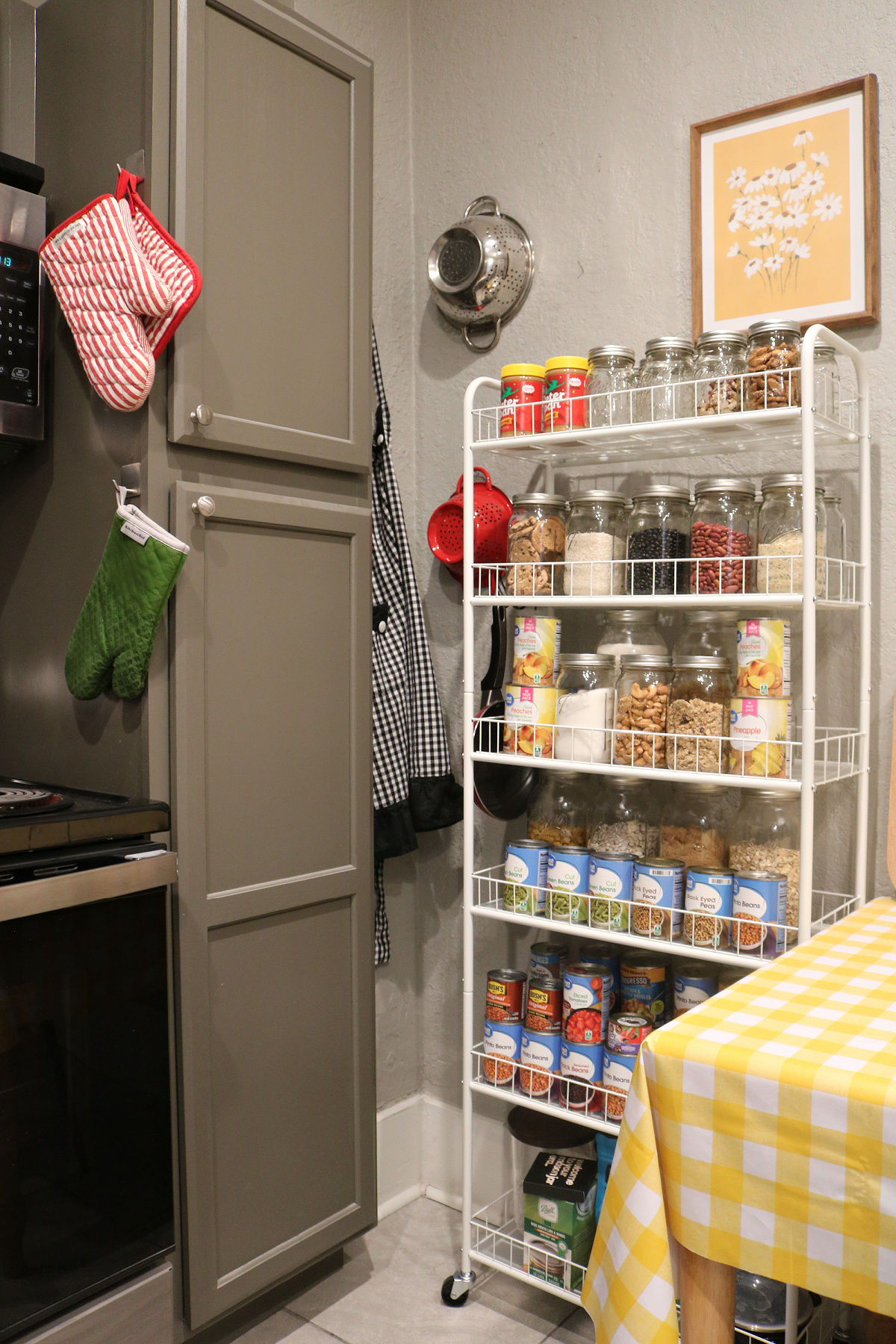 Simple white shelves on wheels I'm using as an open pantry next to kitchen table.