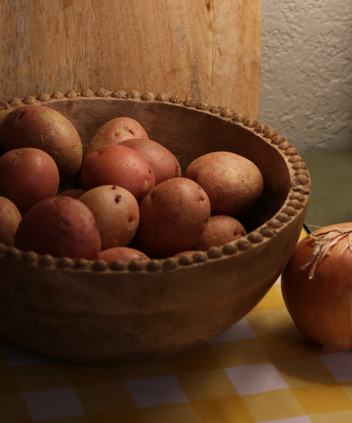 A wooden bowl of red potatoes on my table.