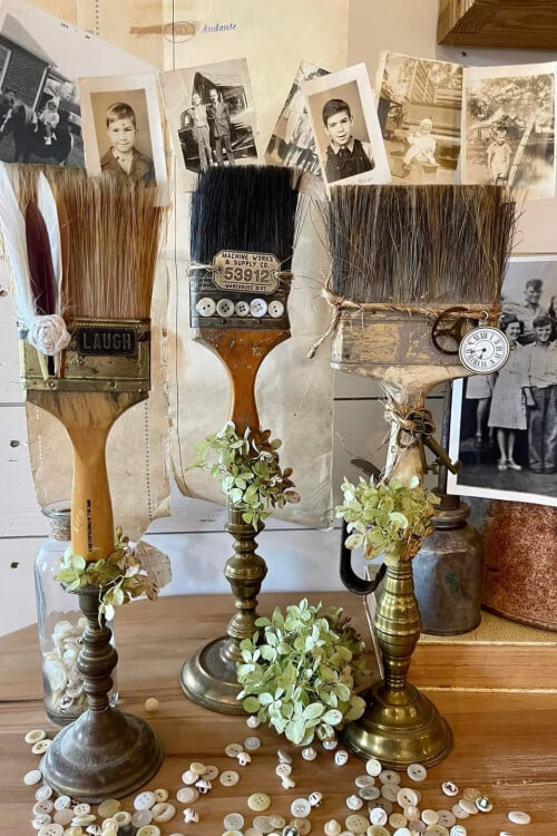 Vintage paintbrushes upcycled with the wooden ends placed in brass candlesticks.