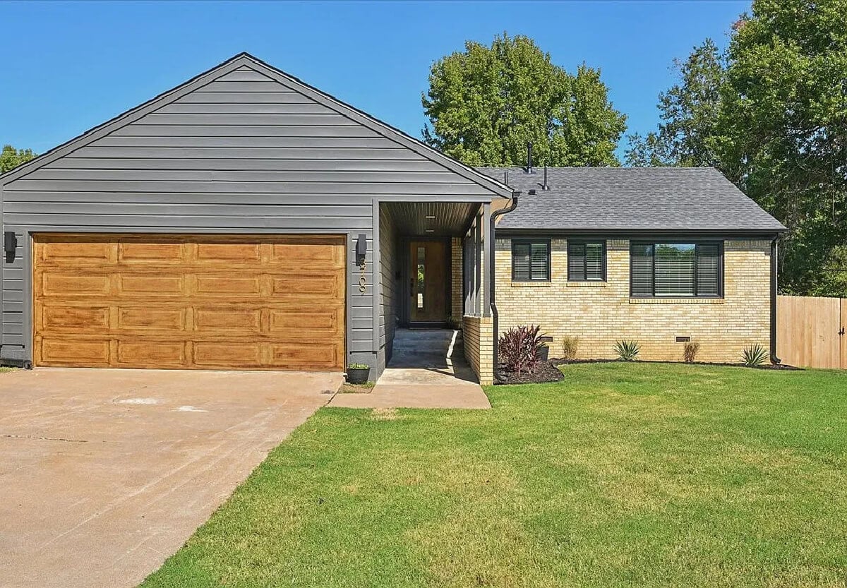 The hoarder house has been transformed, and here is the front yard, new garage door, and fence.